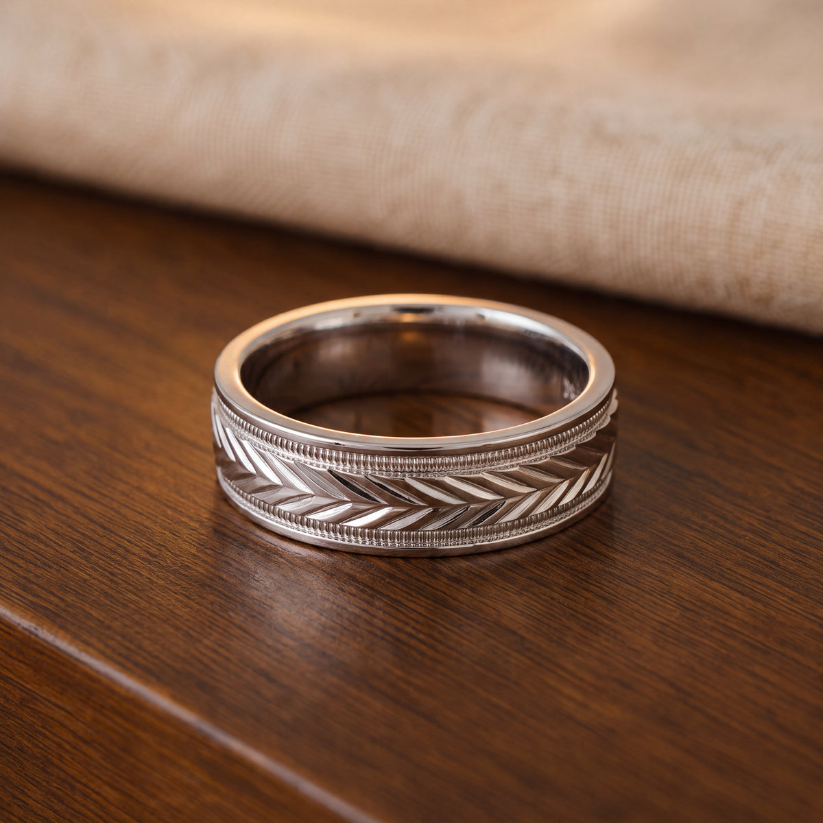 White gold wedding band engraved with chevrons and milgrain