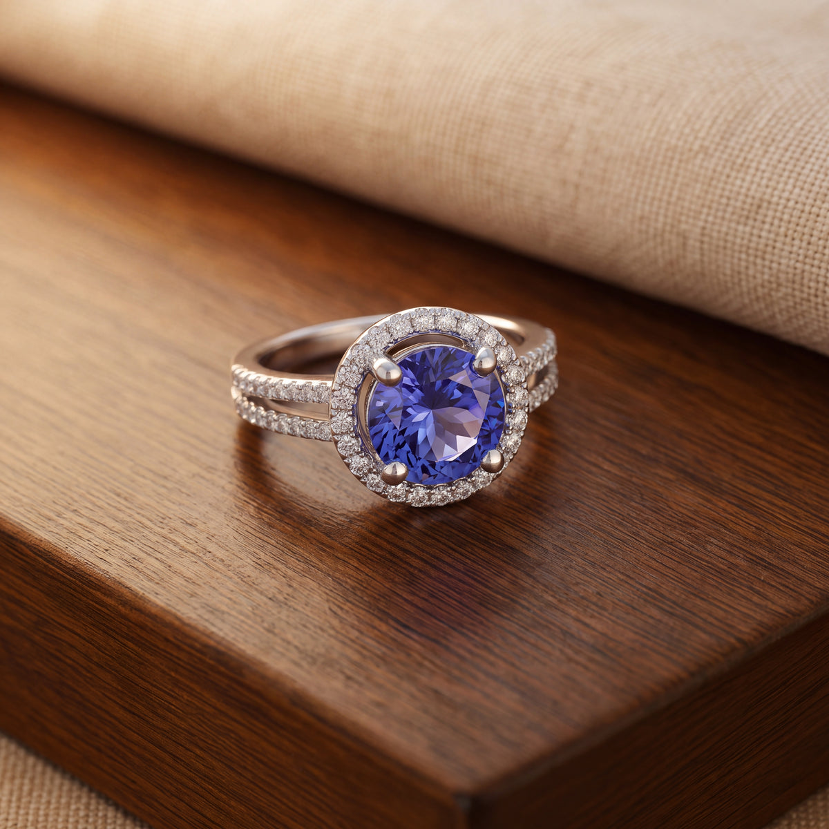 Round tanzanite in four prongs and a halo on a white gold split shank