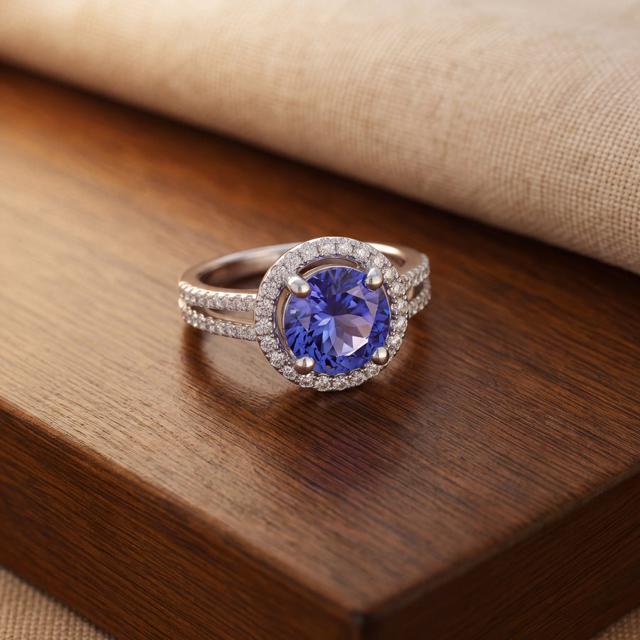 Round tanzanite in four prongs and a halo on a white gold split shank