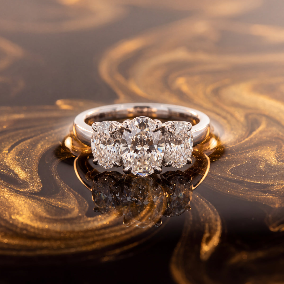 Three-stone ring of oval diamonds on a white gold band