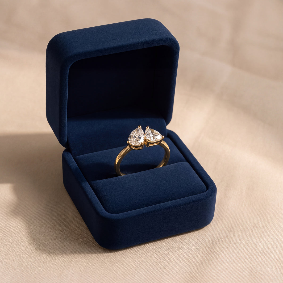 Heart-shaped and pear-shaped diamonds side by side on a yellow gold band