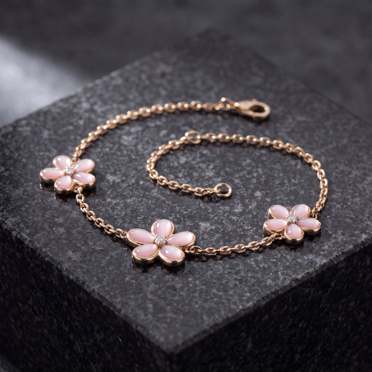 Rose gold chain bracelet with three pink mother-of-pearl flowers