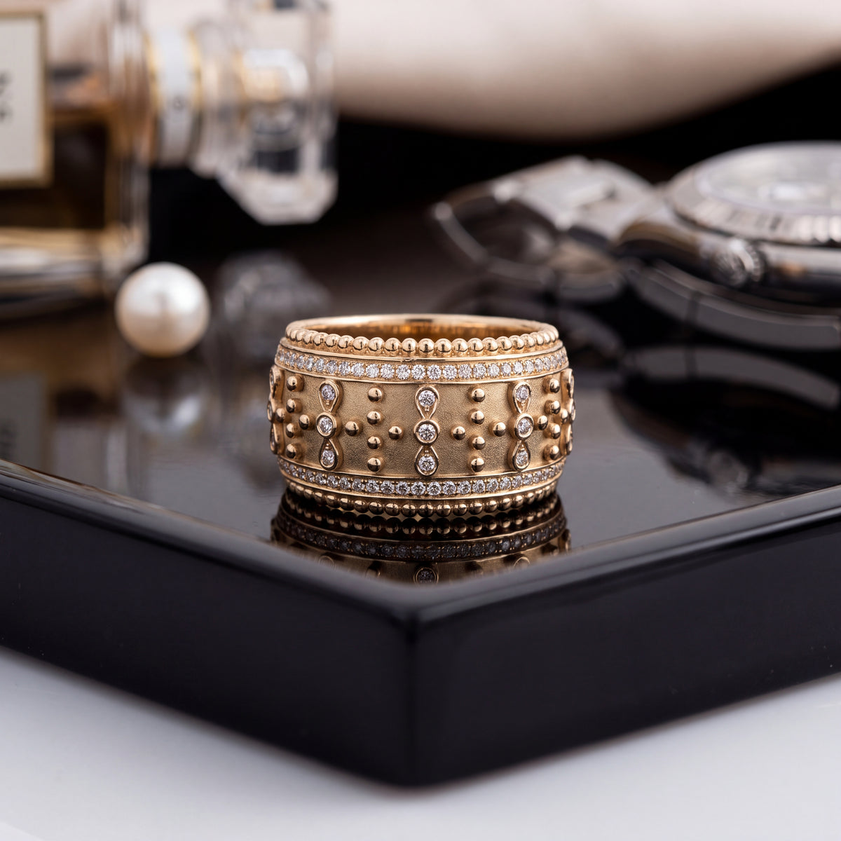 Wide yellow gold band with beading and bezel-set diamonds