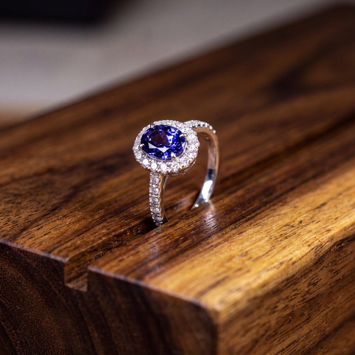 Oval tanzanite in a diamond halo on a pavé white gold band