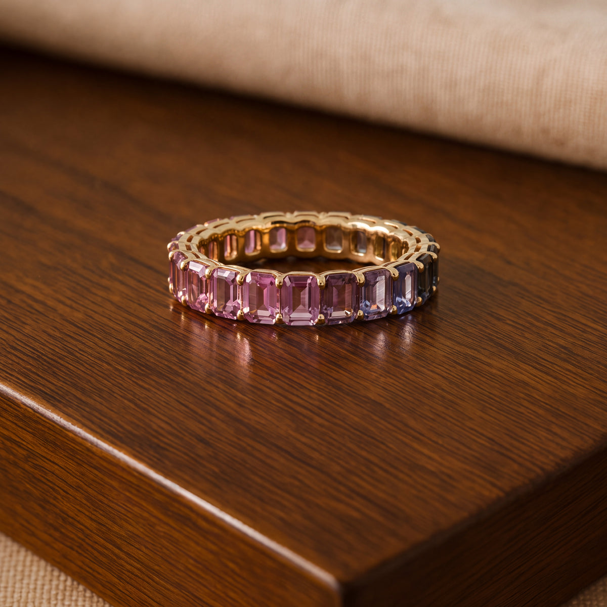 Yellow gold eternity ring of emerald-cut multicolored sapphires