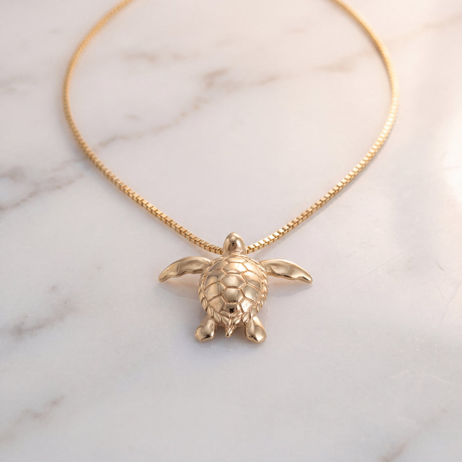 A yellow gold sea turtle charm on a fine chain.