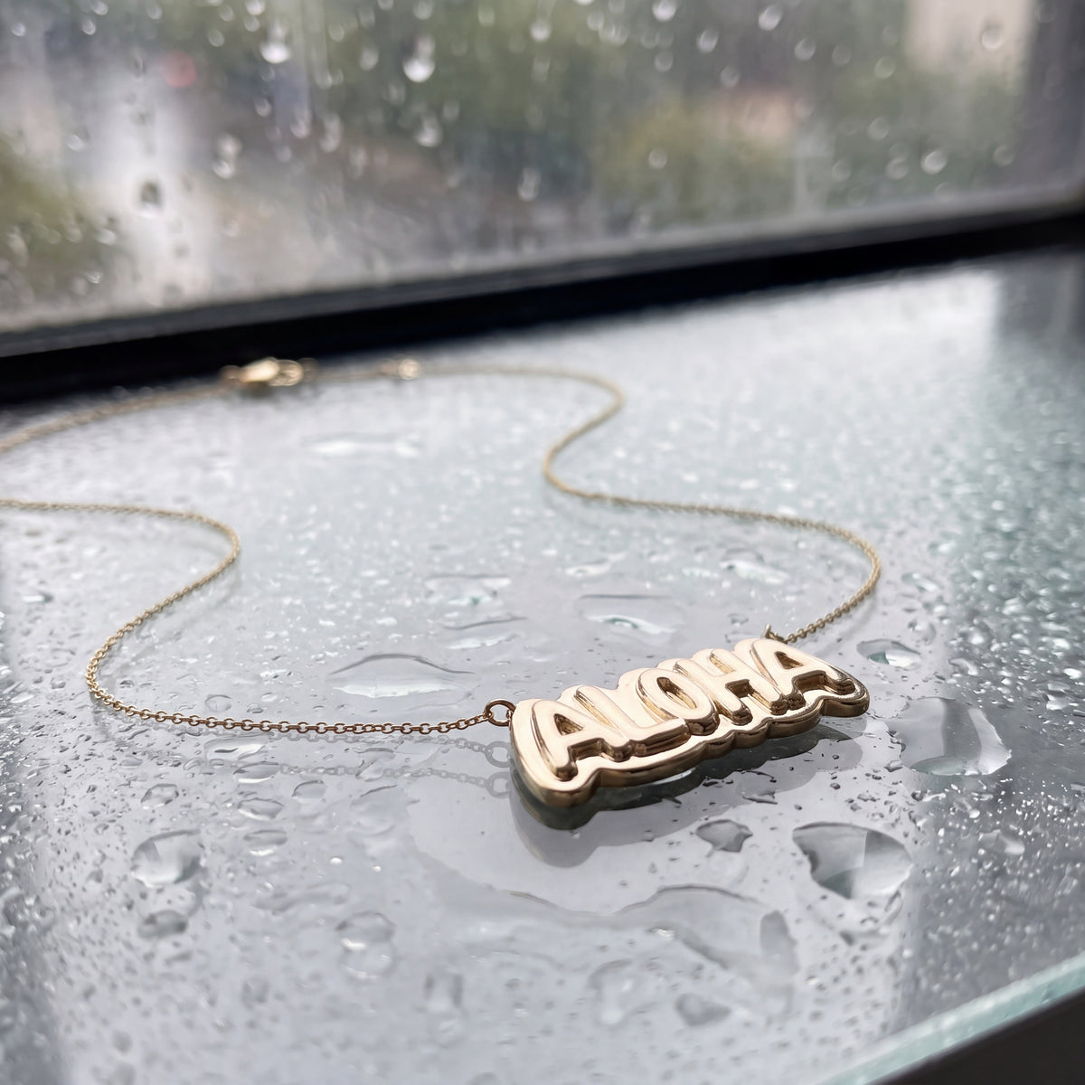 ALOHA letters in yellow gold set into a fine chain