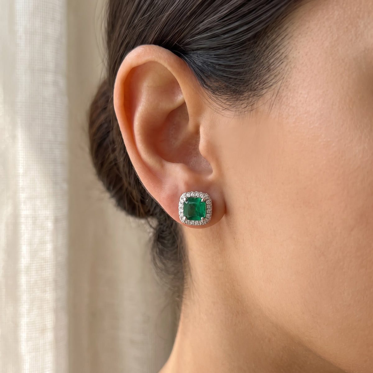 Emerald Halo Stud Earrings in White Gold, worn