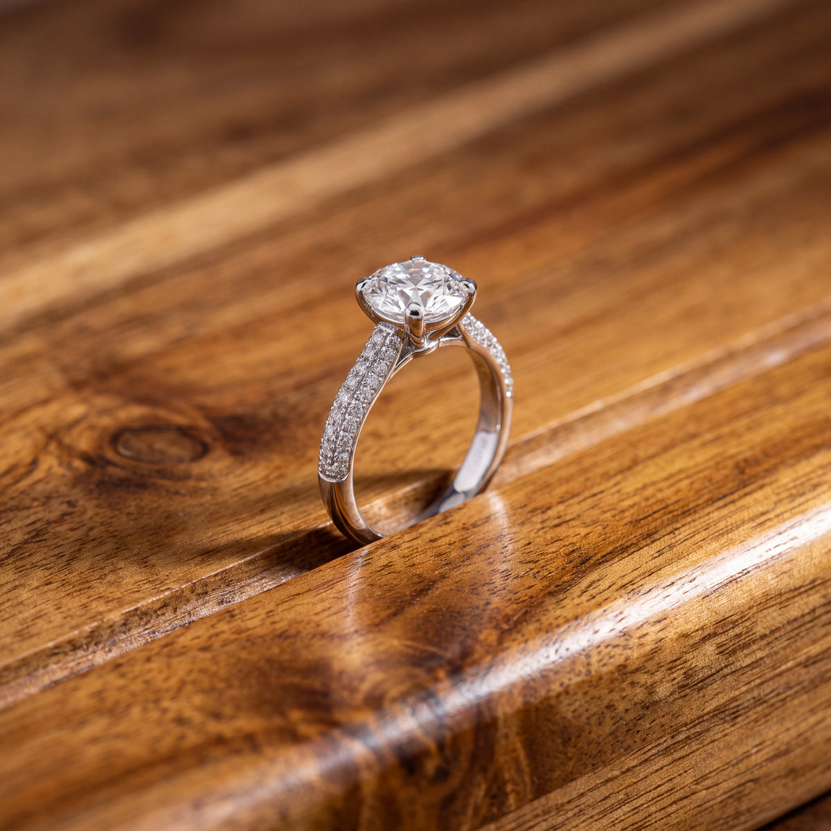 Round diamond solitaire on a white gold band set with pavé diamonds