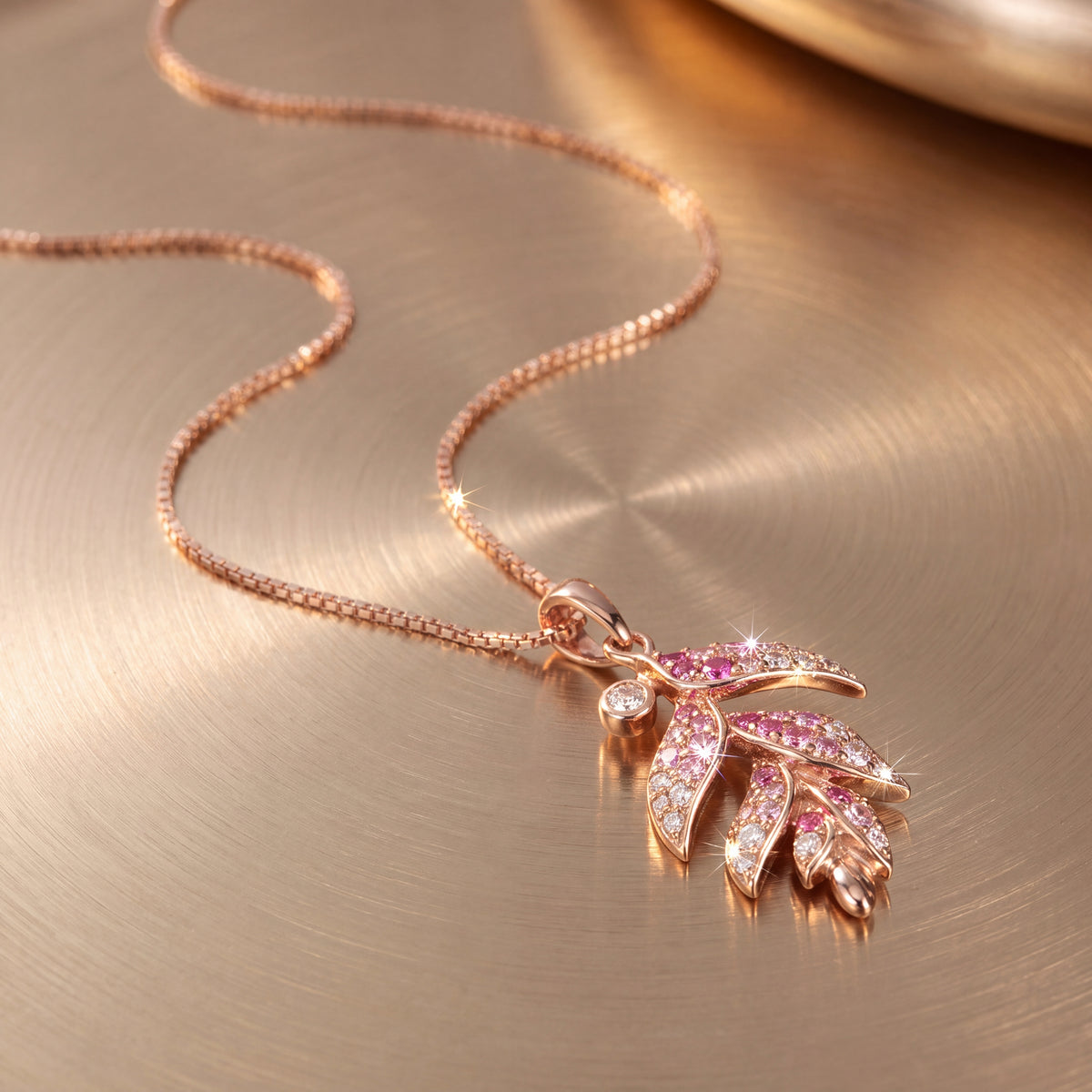 Rose gold botanical pendant of leaves set with pink sapphires