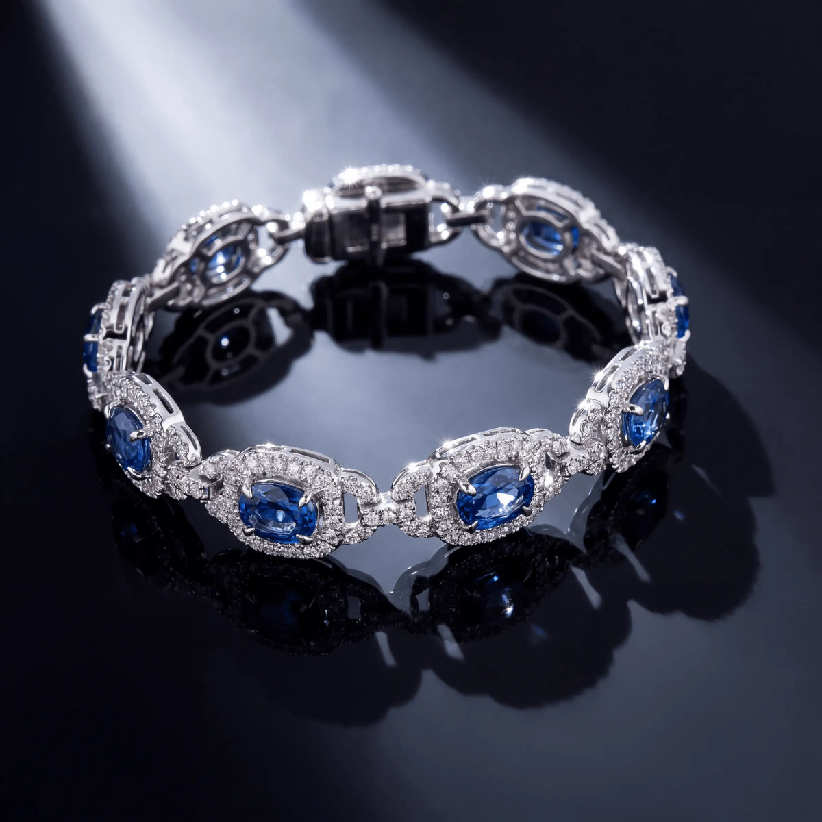 A sapphire and diamond bracelet on a reflective black surface