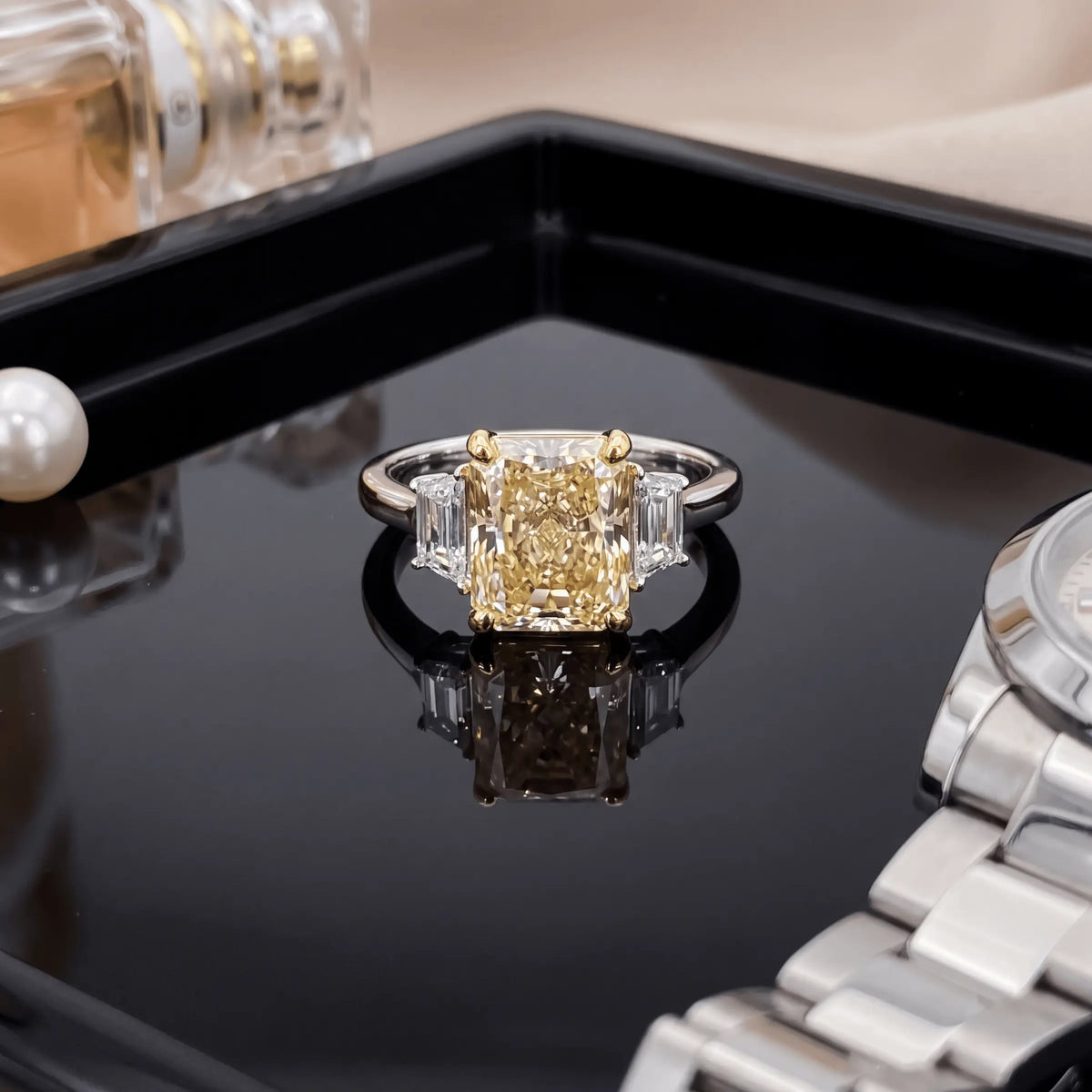 A yellow-center ring styled with a watch and perfume bottle on a dark tray