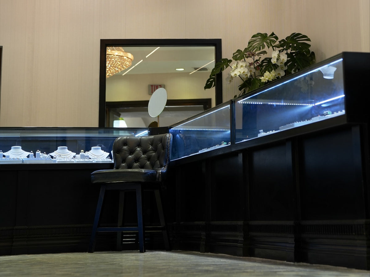 A corner of the counter at Greenleaf Diamonds, a stool and a mirror under the chandelier