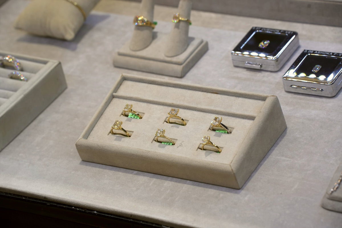 A tray of gold rings set with diamonds in a Greenleaf Diamonds case