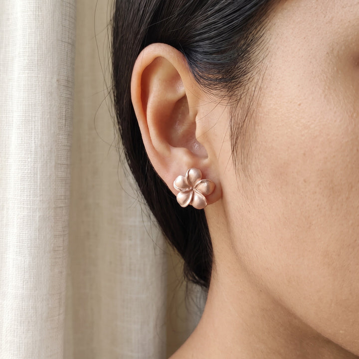 Matte Plumeria Flower Stud Earrings in 14K Rose Gold, worn
