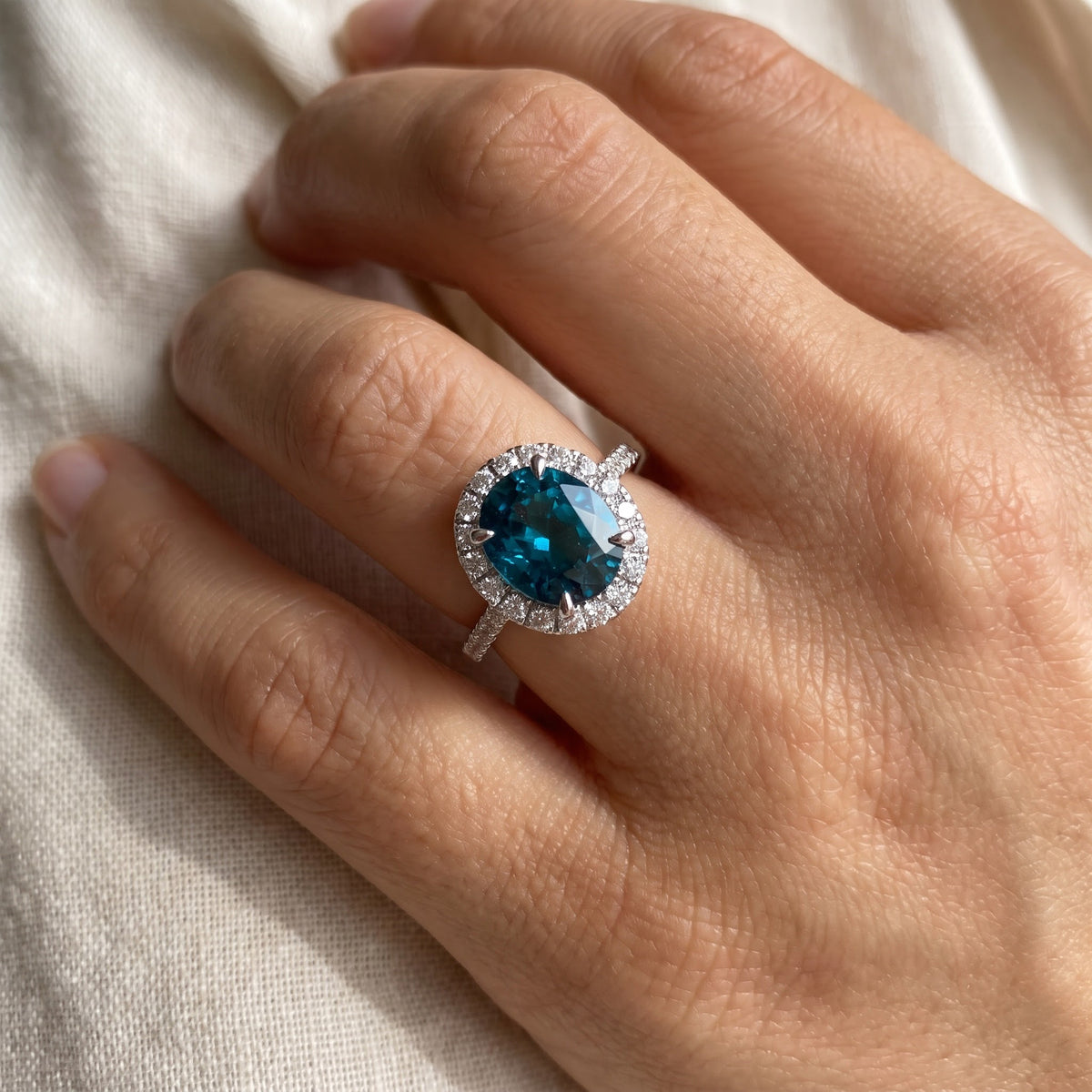 Oval Blue Zircon Halo Ring in White Gold, worn