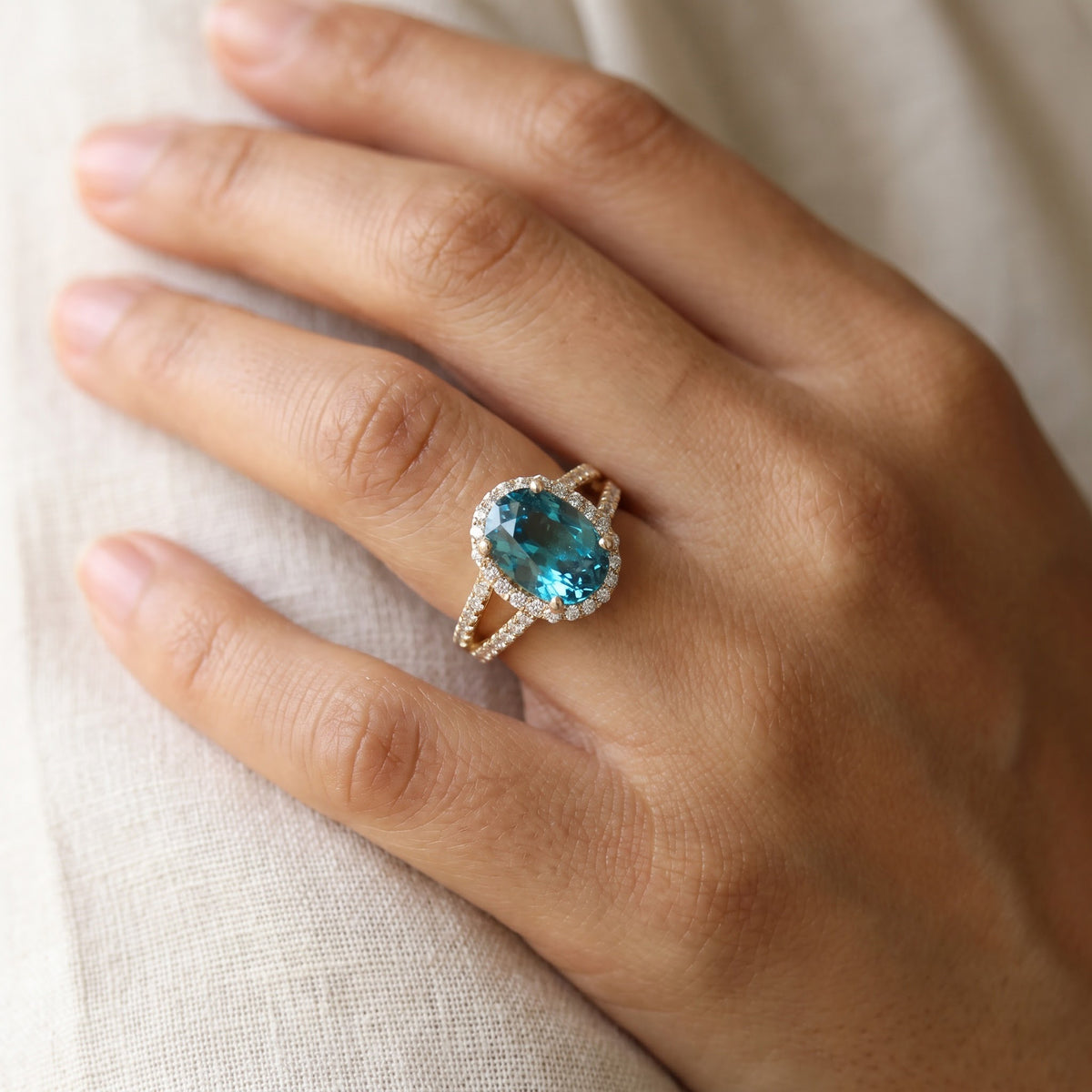 Oval Blue Zircon Split Shank Halo Ring — Yellow Gold, worn