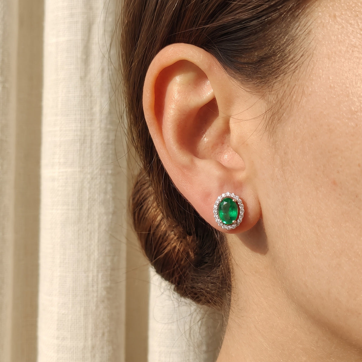 Oval Emerald Halo Cluster Earrings in White Gold, worn