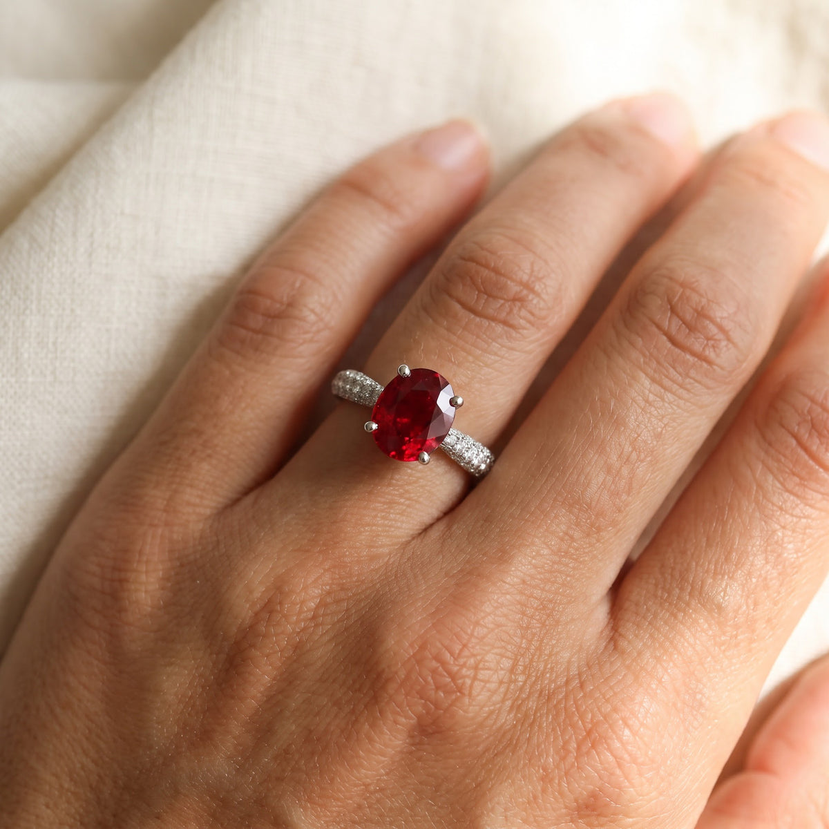Oval Ruby Solitaire Ring with Diamond Pavé Band in White Gold, worn