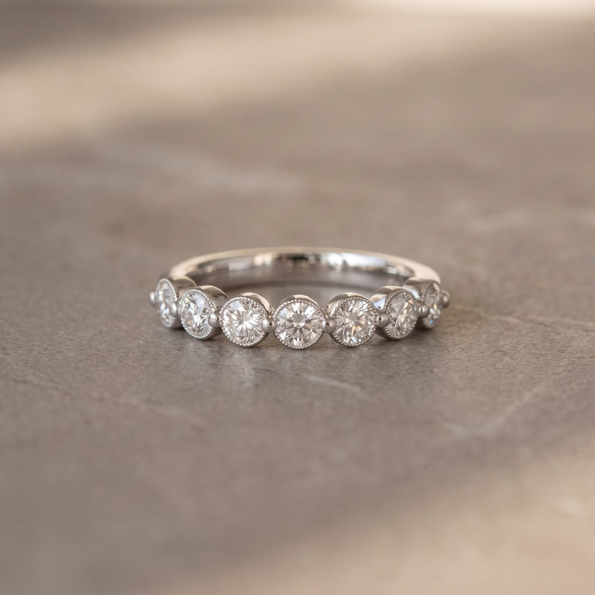 Platinum band set with a row of round diamonds in shared prongs