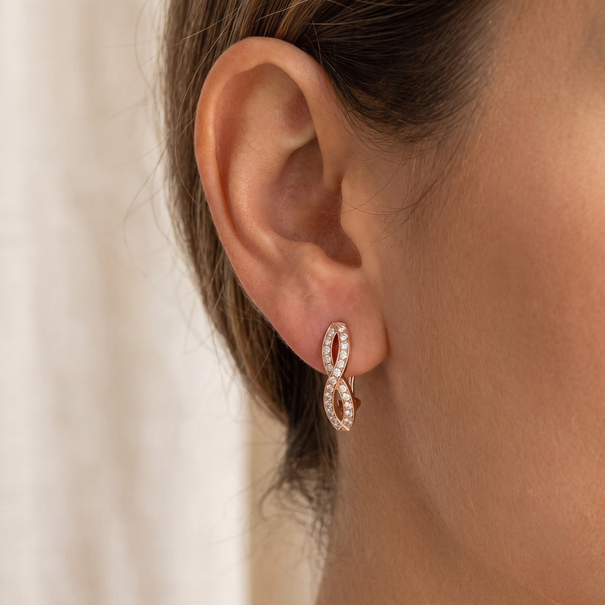 Rose Gold Diamond Infinity Twist Clip-On Earrings, worn