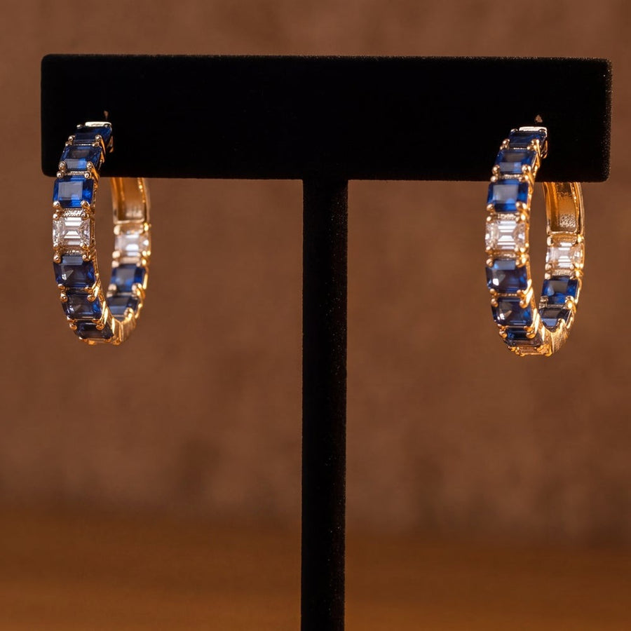 Yellow gold hoop earrings lined with blue sapphires