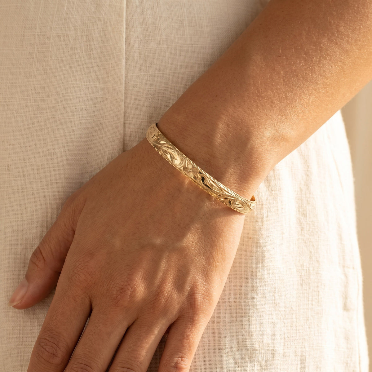Yellow Gold Floral Scroll Engraved Bangle Bracelet, worn